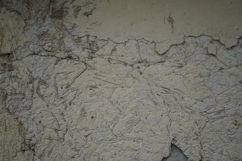 Textured mud wall surface with straw and clay plaster finish in a rural setting. Stock Photos
