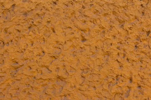 Textured orange wall surface showcasing unique patterns created Stock Photos