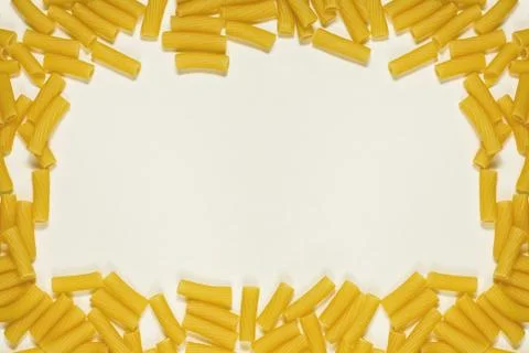 Textured paper background with frame of dry pasta Stock Photos