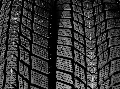 Textured pattern of directional tread blocks on a car tire Foto stock