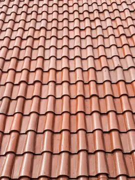 Textured pattern of reddish brown terracotta roof tiles. Stock Photos