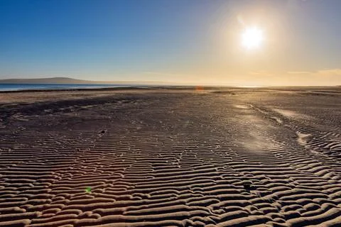 Textured pattern of Ripples in beach sand at sunrise Stock Photos