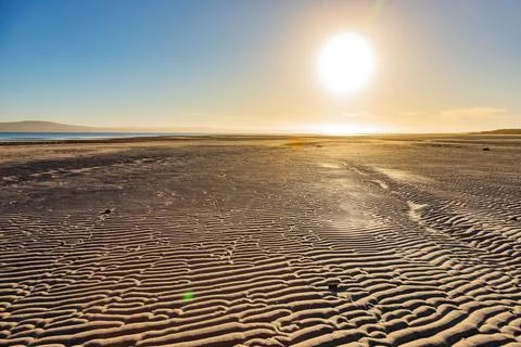 Textured pattern of Ripples in beach sand at sunrise Stock Photos