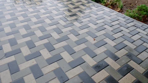 Textured paving stones create a visually appealing pattern on a wet surface Stock Footage 318713471