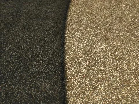 Textured pebble aggregate floor with a stark contrast between sunlight. Stock Photos