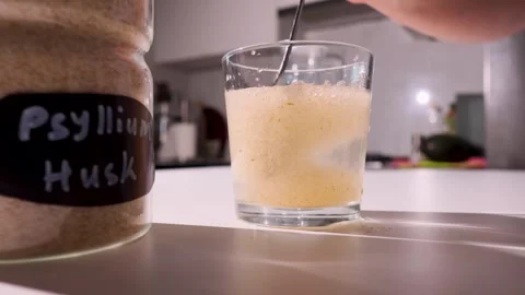 Textured psyllium husk in water forming a thickening gel on a kitchen counter Stock Footage 346309605