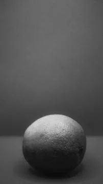 A textured round object rests elegantly on a minimalistic surface under sof.. Stock Photos