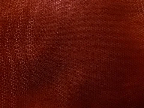 Textured rust brown synthetic athletic fabric background close up view showca Stock Photos