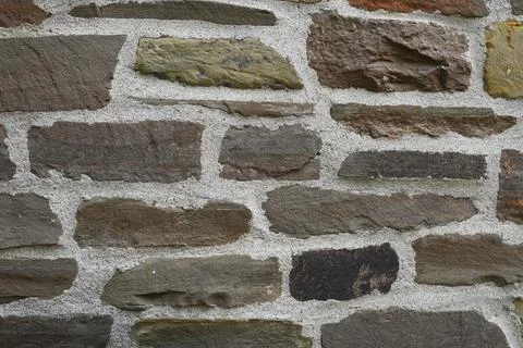 Textured rustic wall made of natural stone blocks Stock Photos