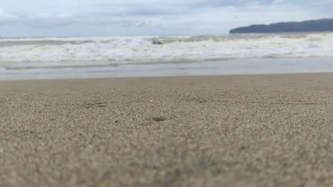 Textured Sand on Beach with Ocean Waves and Distant Coastline Stock Footage 320415107