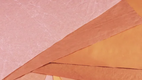 Textured sheets of handmade paper in earthy pink, sakura and terracotta tones. Stock Footage 330242901