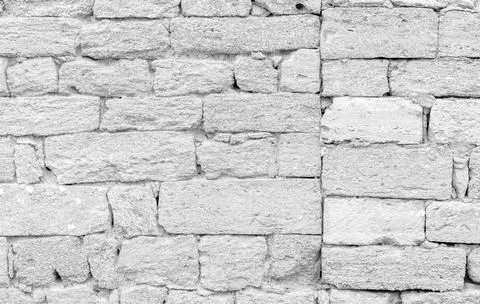 A textured shell rockwall made of irregular, weathered blocks in neutral be.. 库存照片