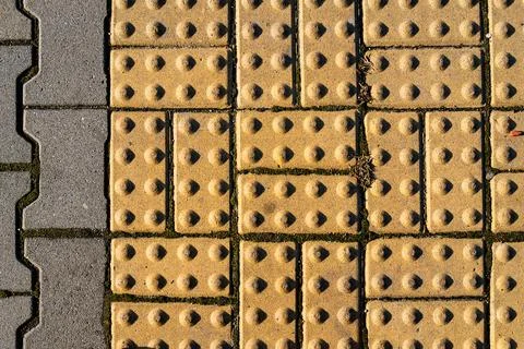 Textured sidewalk with tactile paving for accessibility in an urban environment Stock Photos