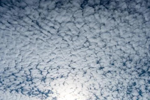 Textured sky filled with cloud formations against a soft blue canvas. Stock Photos