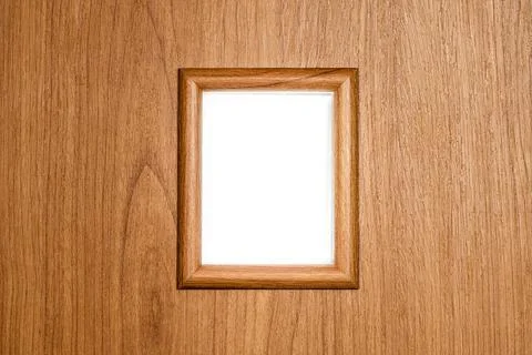 Textured small decorative window in a frame on a wooden wall Stock-Fotos