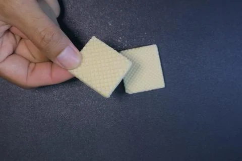 Textured square biscuits on black background Foto stock