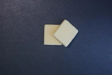 Textured square biscuits on black background Stock Photos
