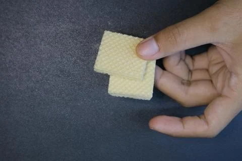 Textured square biscuits on black background Foto stock