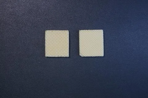 Textured square biscuits on black background Stock Photos
