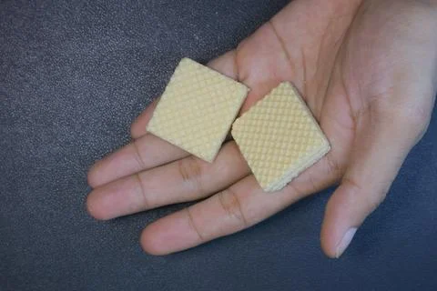 Textured square biscuits on black background Foto stock