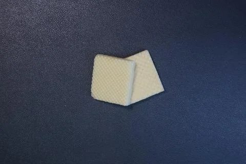 Textured square biscuits on black background Foto stock