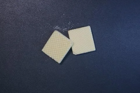 Textured square biscuits on black background Foto stock