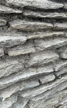 Textured stack stone wall detail showing natural rock layers and cement bindi Stock Photos