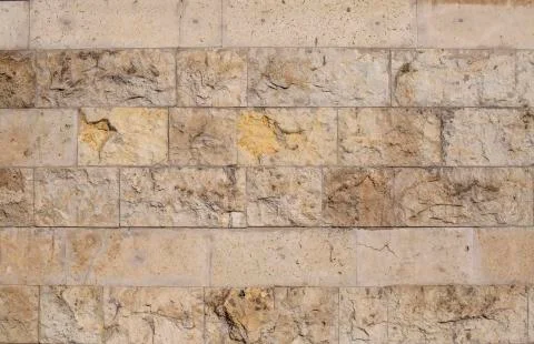 Textured stone wall close-up. The background. Limestone. Stock Photos