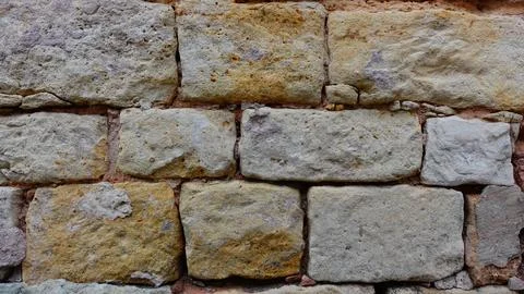 Textured Stone Wall Featuring Irregular Bricks in Warm Earth Tones Foto stock