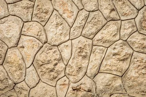 Textured stone wall with irregular pattern and natural earth tones Stock Photos
