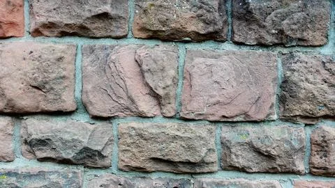Textured Stone Wall Made of Rough, Weathered Bricks in Natural Hues Stock Photos