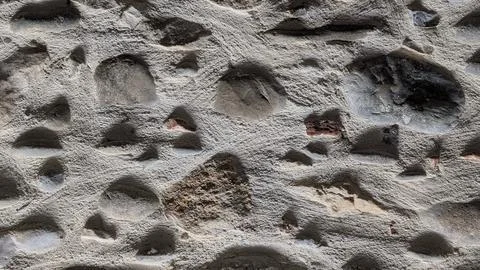 Textured stone wall with rounded pebbles close-up Stock-Fotos