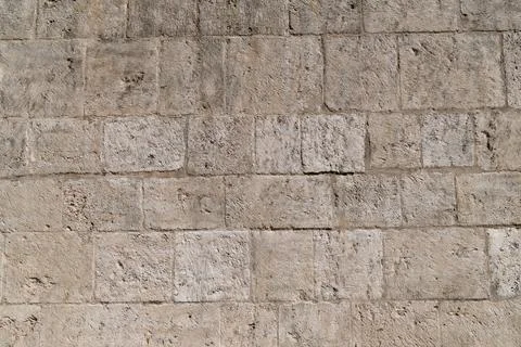 Textured stone wall with uniform pattern of beige blocks Stock Photos