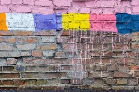 Textured surface of a brick wall with multicolored spots Stock Photos