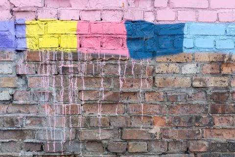 Textured surface of a brick wall with multicolored spots Foto stock
