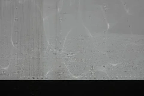 A textured surface features light reflections and subtle patterns of water ca Stock Photos