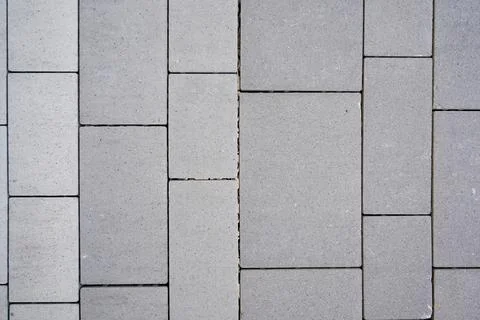 The textured surface of gray rectangular pavement stabs - background with cop Stock Photos