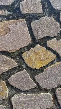 Textured surface of a stone wall, exuding earthy colors and intricate pattern Stock Photos