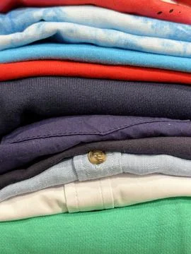 Textured view of stack of new clothes and t-shirts in the shop Stock Photos