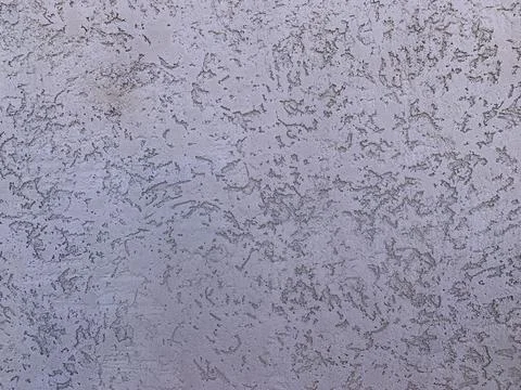 A textured wall captures intricate patterns with muted tones, showcasing a blend Stock Photos