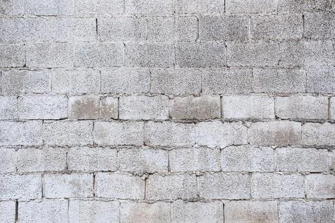 Textured wall is constructed from a grid of rough, gray concrete blocks. Vi.. 스톡 사진