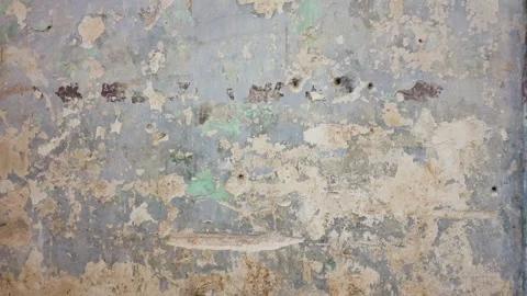 A textured wall featuring layers of peeling paint in muted shades Stock Footage 316235847