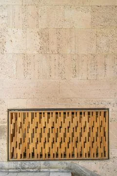Textured wall lined with shell rock tiles with a decorative wooden panel Stock Photos