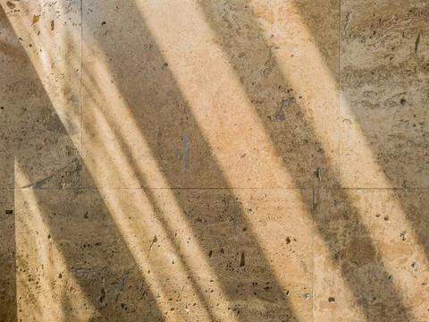Textured wall lined with shell rock tiles with a shadow lines from the lattic Stock Photos