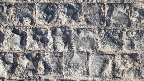 Textured wall made gray square stone blocks, showcasing modern masonry and mi Stock Photos