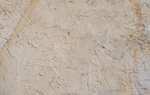 Textured wall surface features intricate patterns and varying shades of bei.. Stock Photos