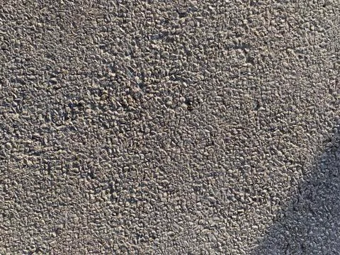 Textured wall surface of tiny stones in sunlight exterior Foto stock