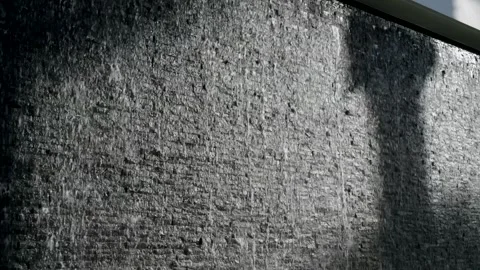 Textured wall with water cascading down on surface. Quick flow of liquid Stock Footage 276374157