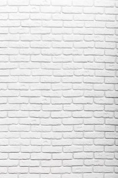 Textured white brick wall provides a clean background for creative designs and Stock Photos