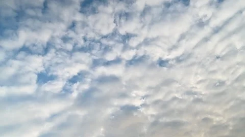 Textured White Clouds Drifting Across a Blue Sky Stock Footage 341849346